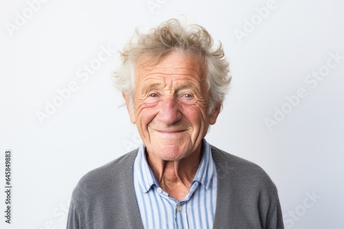 Medium shot portrait photography of a French man in his 70s against a white background