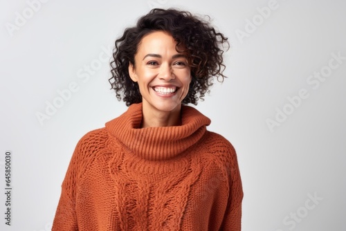 Portrait photography of a Colombian woman in her 40s wearing a cozy sweater against a white background