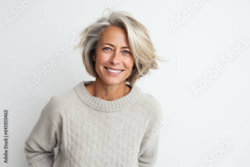 Lifestyle portrait photography of a Swedish woman in her 40s wearing a cozy sweater against a white background
