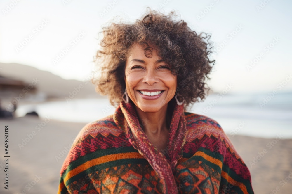 Medium shot portrait photography of a Peruvian woman in her 50s wearing a cozy sweater against a beach background