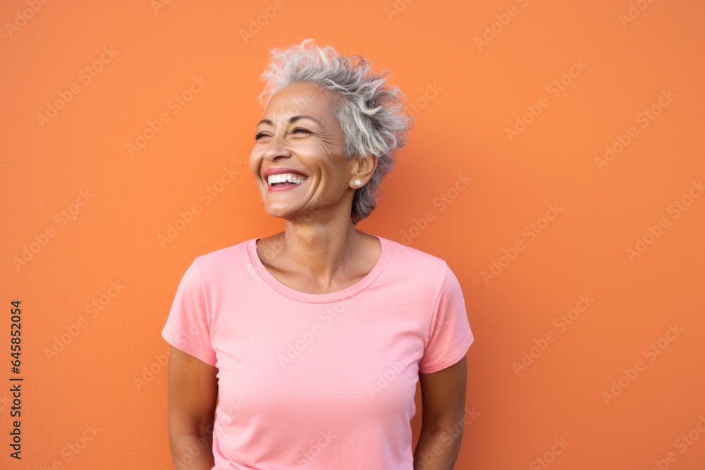 Lifestyle portrait photography of a Colombian woman in her 60s wearing a casual t-shirt against an abstract background Lifestyle portrait photography of a Colombian woman in her 60s wearing a casual t-shirt against an abstract background