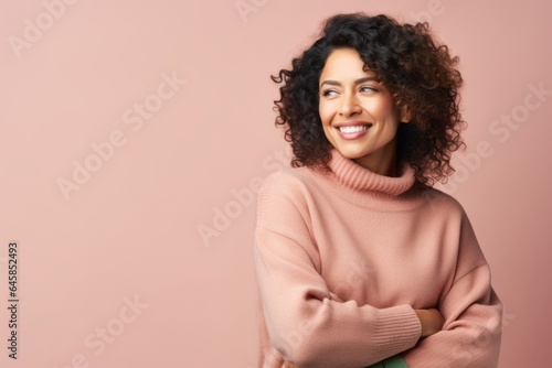 Portrait photography of a Colombian woman in her 40s wearing a cozy sweater against a pastel or soft colors background