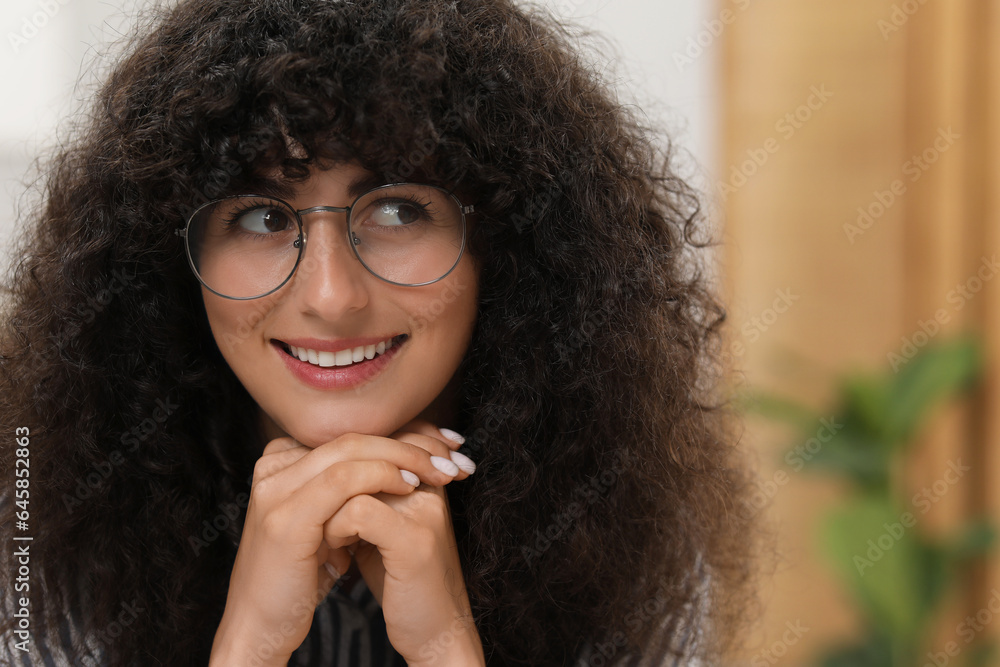Portrait of beautiful woman in glasses indoors. Attractive lady smiling and posing for camera. Space for text Portrait of beautiful woman in glasses indoors. Attractive lady smiling and posing for camera. Space for text