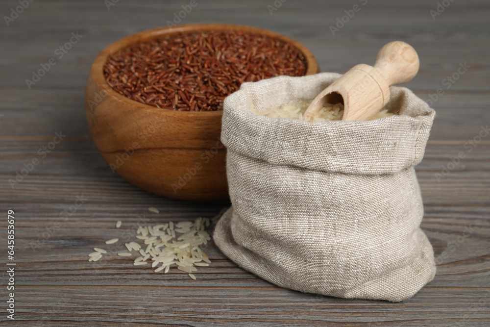 Bag and bowl with different sorts of rice on wooden table