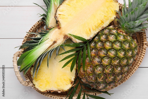 Whole and cut ripe pineapples on white wooden table, top view