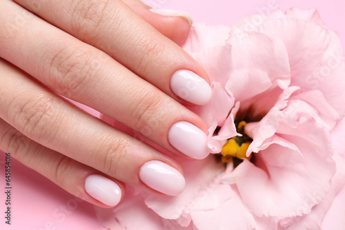 Woman with white nail polish touching eustoma flower  closeup