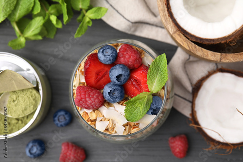 Tasty oatmeal with berries and mint on black wooden table  flat lay. Healthy breakfast