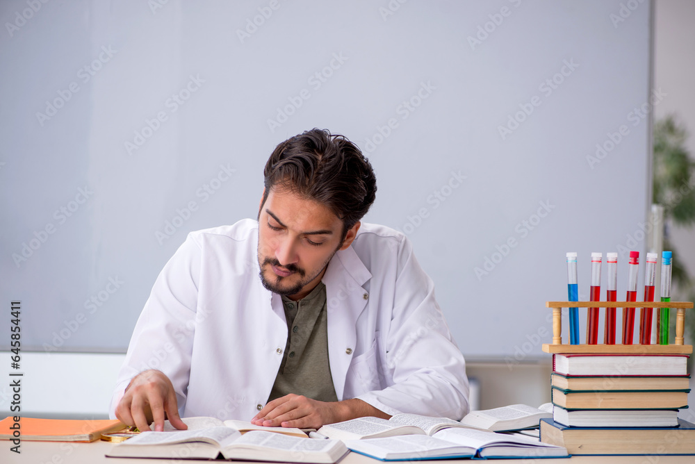 Young male chemist teacher in front of whiteboard Young male chemist teacher in front of whiteboard