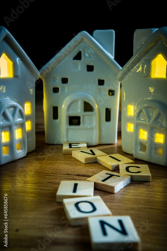 eviction sign in wooden letters leading to ceramic house with light off housing crisis estate agency homeless crisis