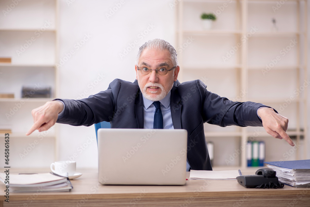 Old male employee working in the office Old male employee working in the office