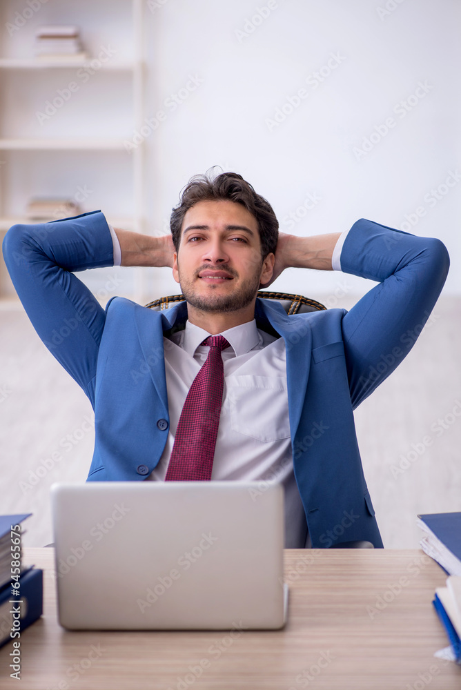 Young male employee working in the office Young male employee working in the office