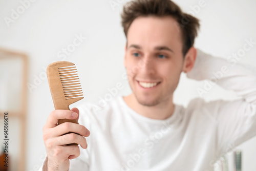 Young man with hair comb in...