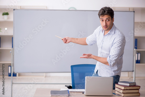 Young male teacher in front of white board