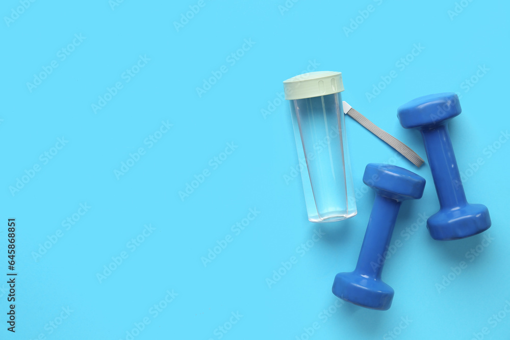 Bottle of water and dumbbells on color background Bottle of water and dumbbells on color background