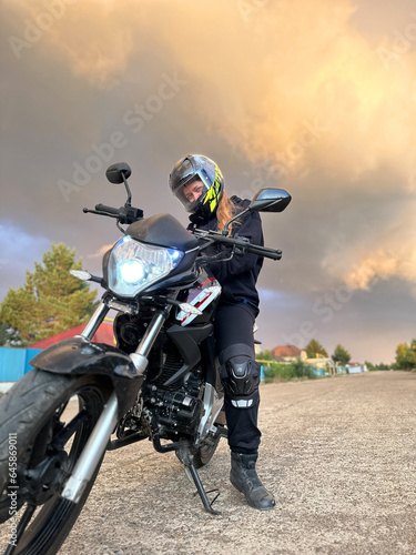 woman motorcyclist in a helmet  motorcycle gloves  motorcycle boots on a motorcycle close-up