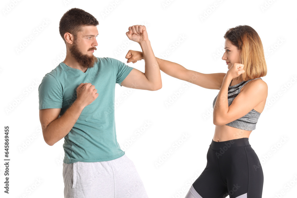 Young woman fighting with instructor of self-defence course on white background Young woman fighting with instructor of self-defence course on white background