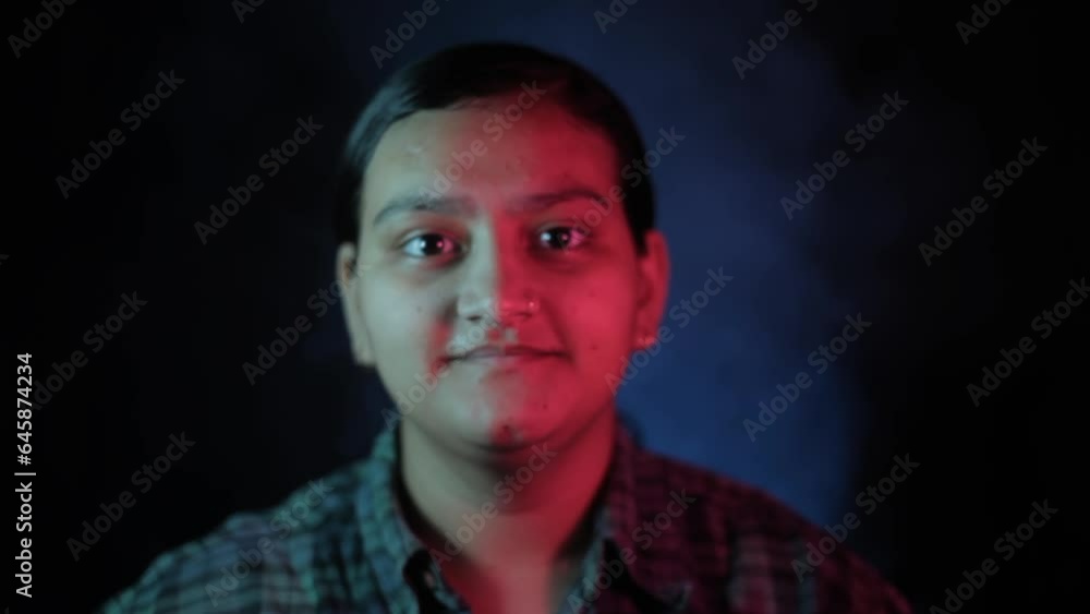 Close-up shot of a girl wearing a green shirt colored giving facial expression of agreeing, sitting in a club like setting. Hd stock footage.