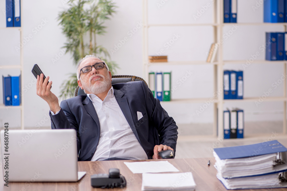 Old male employee working in the office Old male employee working in the office