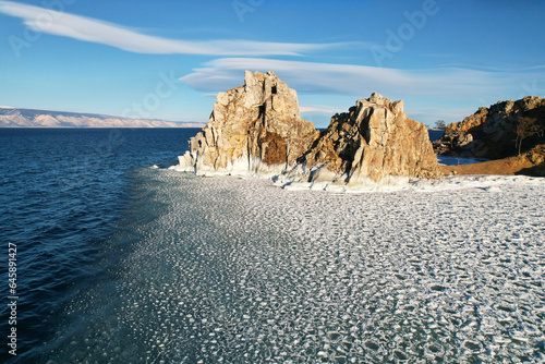 Lake Baikal in December. Cape Burkhan on Olkhon Island at the beginning of winter. A famous landmark, a popular tourist spot on Lake Baikal. Open water in the lake and ice floes. photo