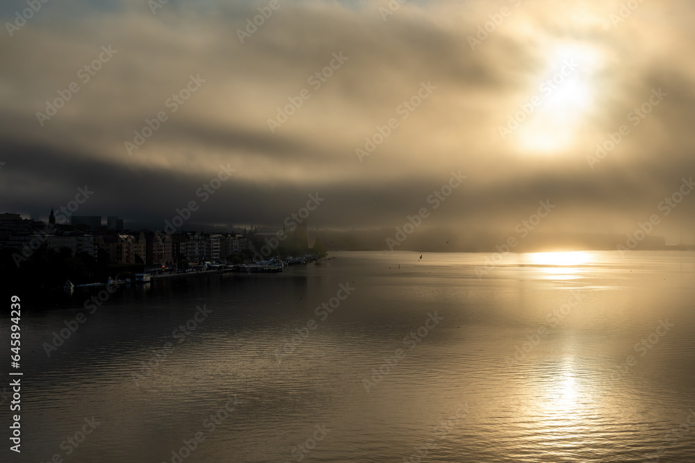 Stockholm, Sweden Fog and the sunrise over the Ridddarfjarden bay in downtown create a dramatic landscape