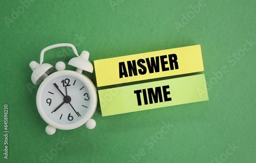 alarm clock and colored paper with the word answer time. the concept of answering questions. the concept of time to answer. business concept or quiz time.
