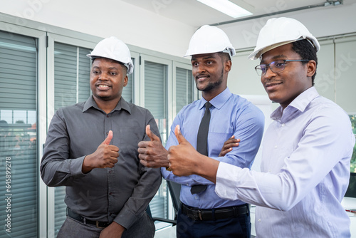 Three male engineers standing and giving thumbs up