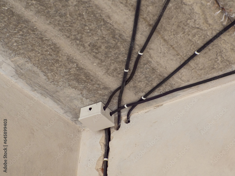 White plastic electric junction box with conduits install in house ceiling. Professional draft electrical wiring in house or apartment during repair, installation of junction box, high voltage. White plastic electric junction box with conduits install in house ceiling. Professional draft electrical wiring in house or apartment during repair, installation of junction box, high voltage.