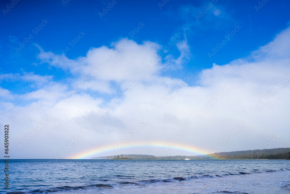 rainbow over the ovean and above an island