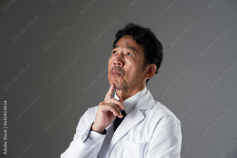 考える中年の医師　黒背景
