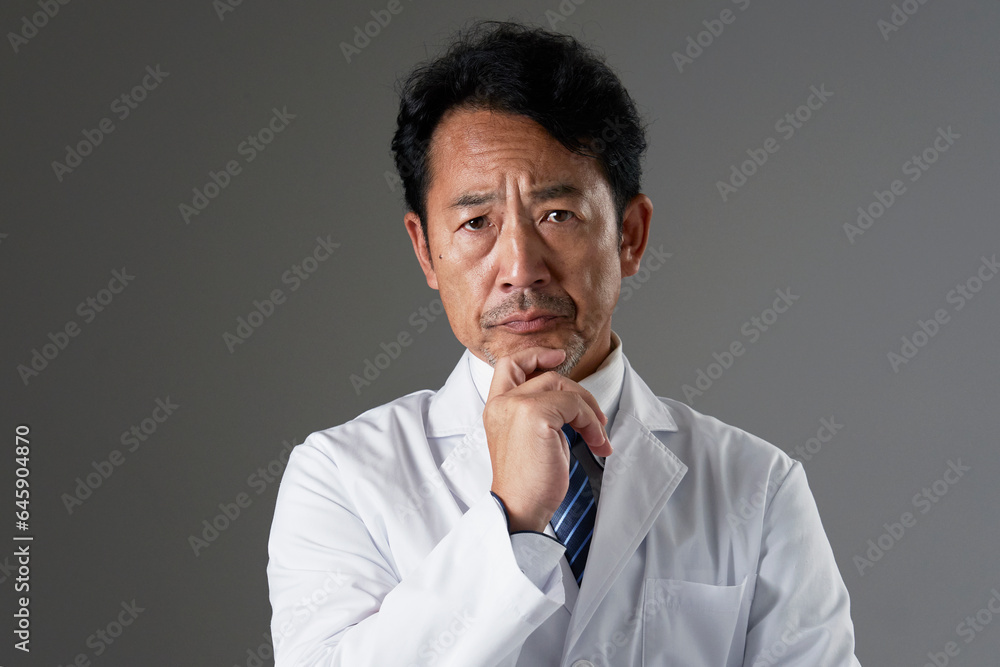 考える中年の医師　黒背景
