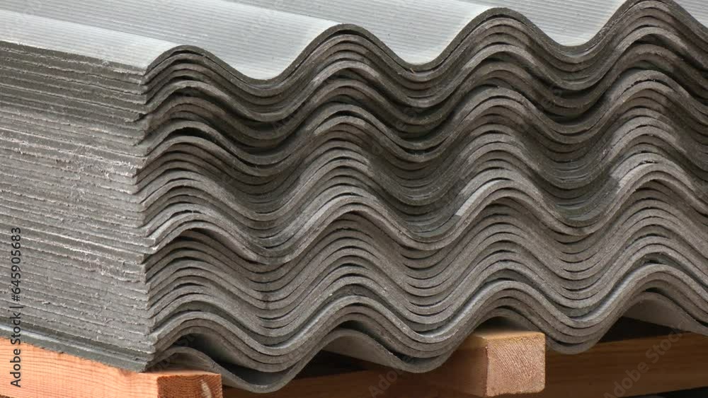 A large number of gray curved roof tiles overlap many layers in order to be organized. Stack of new corrugated slate sheets. Many gray slate sheets are stacked on top of each other. A large number of gray curved roof tiles overlap many layers in order to be organized. Stack of new corrugated slate sheets. Many gray slate sheets are stacked on top of each other.