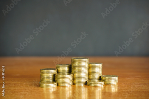 Pile of golden money coin on wood desk and black background. Business and financial concept. 