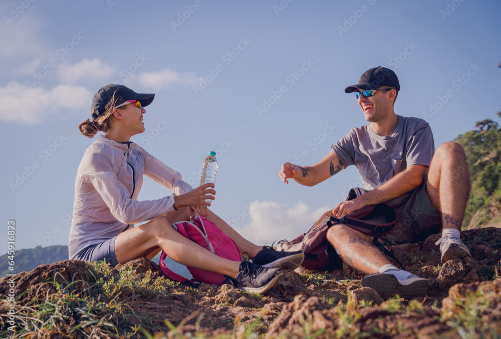 Happy young couple relax after climbs to the top of the mountains near the ocean