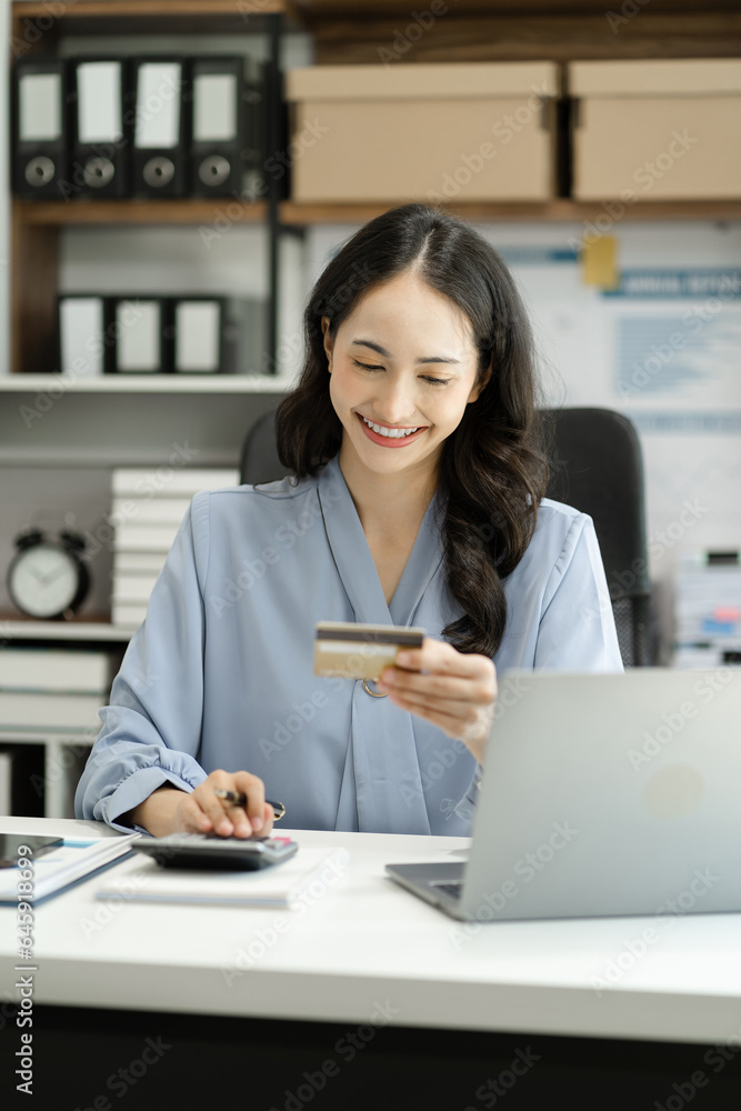 Business woman use a credit card with a calculator for internet payment at office in the morning. Business woman use a credit card with a calculator for internet payment at office in the morning.