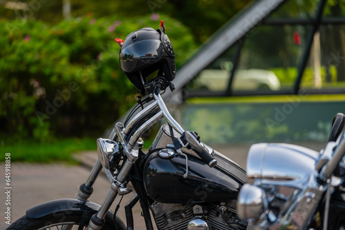 Helmet hanging on modern style black chopper type motorcycle for bikers