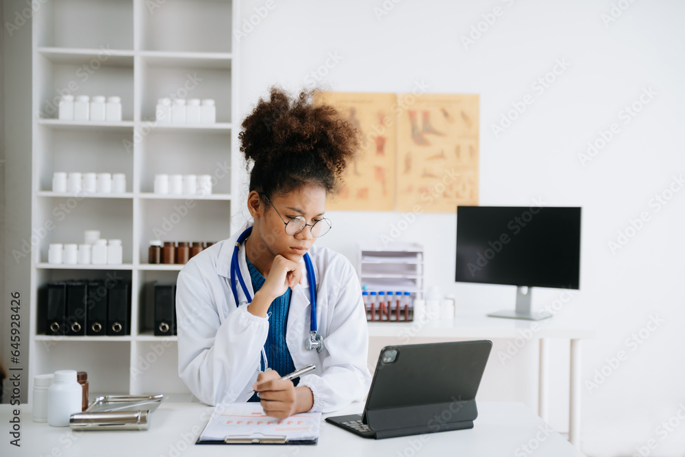 Beautiful physician doctor sit on table in office hospital. Attractive therapist female practitioner pharmacist smile and use tablet and laptop in hospital.after success work from treatment.