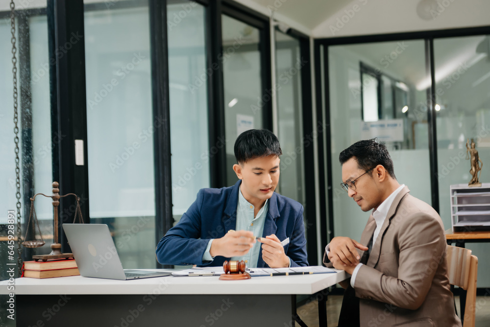 Business law concept, Lawyer business lawyers are consulting lawyers for man entrepreneurs to file copyright lawsuit with laptop and tablet at office Business law concept, Lawyer business lawyers are consulting lawyers for man entrepreneurs to file copyright lawsuit with laptop and tablet at office