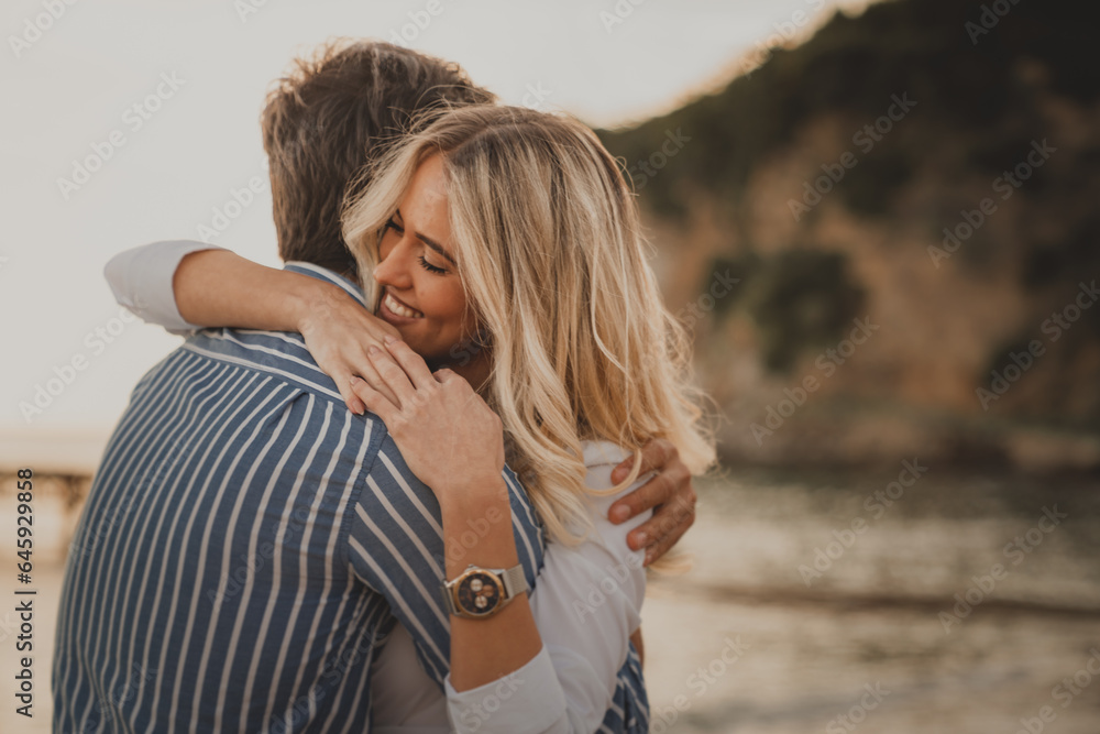 Photo of a lovely couple hugging at the beach. Romantic heterosexual couple spending their summer vacation together and enjoying their time at the sea. Photo of a lovely couple hugging at the beach. Romantic heterosexual couple spending their summer vacation together and enjoying their time at the sea.