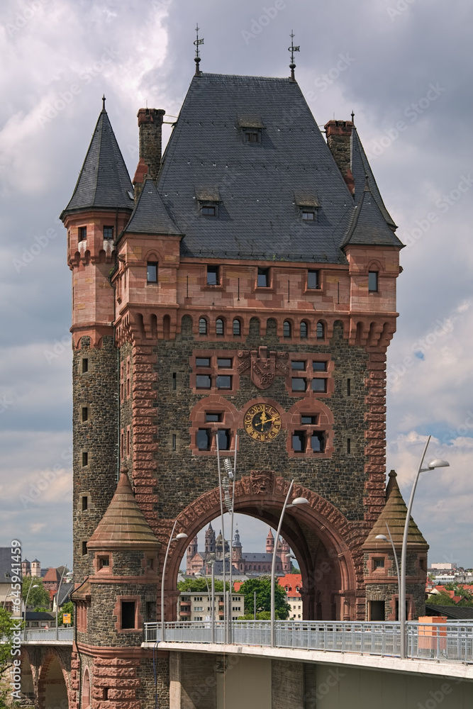 Worms, Germany. Nibelung Tower, a 53 metres tall neo-Romanesque bridge tower of Nibelungen Bridge over the Rhine. It was built in 1897-1900. Worms Cathedral is visible through the gateway of the tower