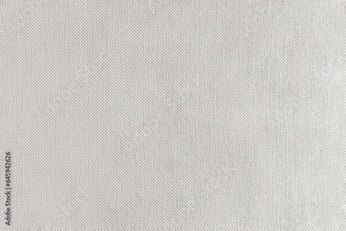 Texture background of white velours fabric. Textile structure, cloth surface, weaving of jacquard material closeup. Upholstery, curtains, backdrop, wallpaper.