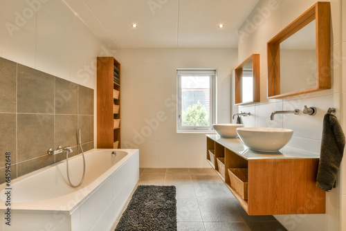 a bathroom with wood cabinets and a white bathtub on the floor in front of the tub  sink and mirror