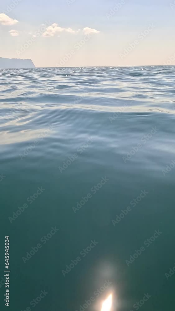 Sea water surface. Low angle view from kayak, camera flies over clear sea water. Nobody. Holiday recreation concept. Abstract nautical summer ocean nature. Slow motion. Close up. Vertical video Sea water surface. Low angle view from kayak, camera flies over clear sea water. Nobody. Holiday recreation concept. Abstract nautical summer ocean nature. Slow motion. Close up. Vertical video