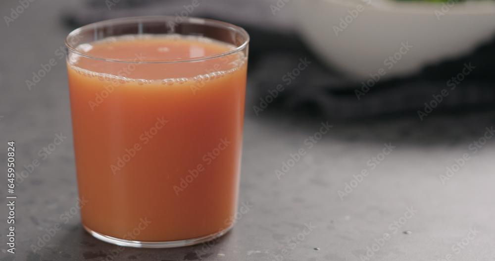 Grapefruit juice in a glass on countertop Grapefruit juice in a glass on countertop