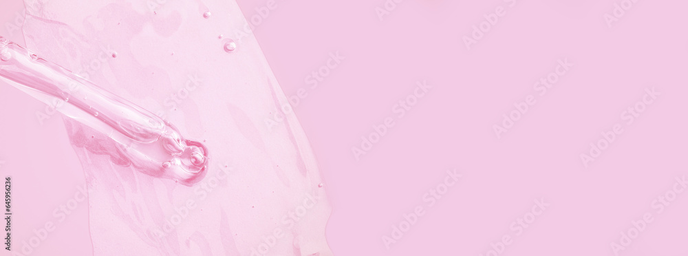 A flowing clear gel from a pipette. Lots of flowing gel smeared on the background. With bubbles. On a pink background.