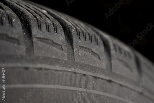 Worn tires macro. Fissures on the black rubber tire. Aged tyres close-up. Cracked wheel safety risks. Automotive service and maintenance.