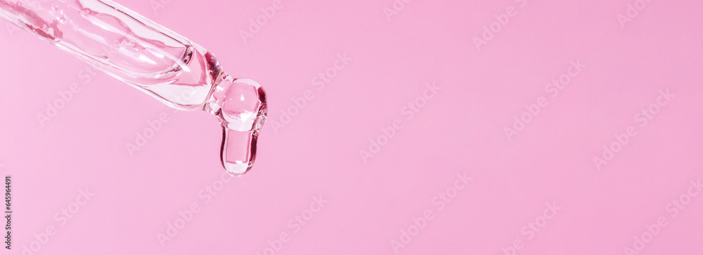 Cosmetic pipette with dripping liquid and drops on a pink background, serum, serum, gel, vitamin, water, oil Cosmetic pipette with dripping liquid and drops on a pink background, serum, serum, gel, vitamin, water, oil