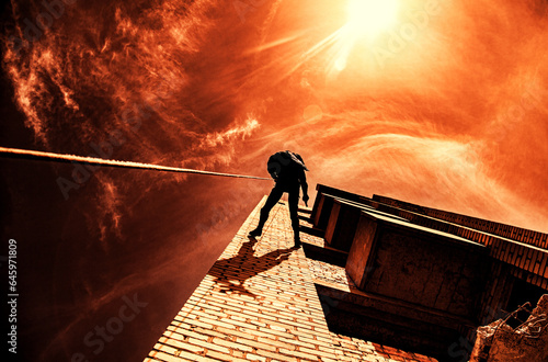 Silhouette of police officer in tactical gear descending from a height, rope exercises with weapons. Tactical rappelling, anti-terror or counter terrorism operation in darkness in rappelling harness photo