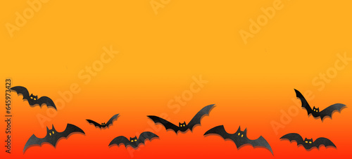 Halloween decorations, paper bats in ghosts flying on orange background. Halloween party greeting card mockup with copy space. Happy halloween holiday concept. Flat lay, top view