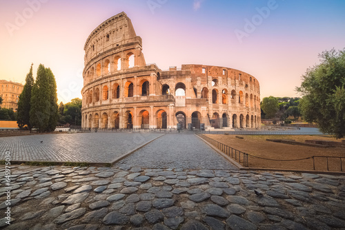 Iconic Flavian Amphitheatre  the ancient Roman Colosseum  a famous tourist landmark illuminated at twilight and dawn in historic Rome  Italy.