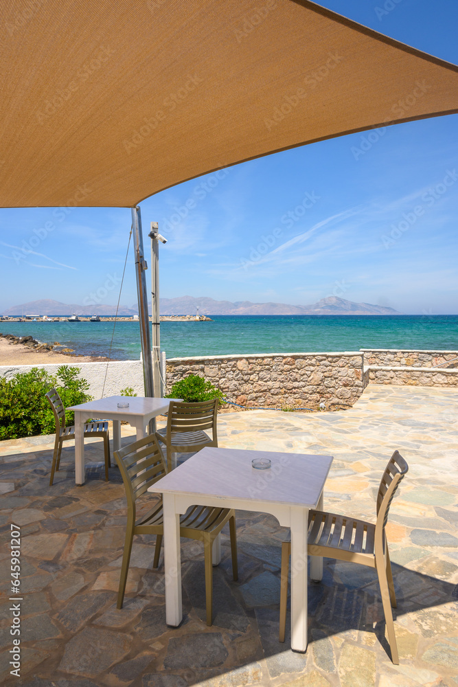 Tables and chairs overlooking the beach and sea on the island of Kos. Mastichari village.